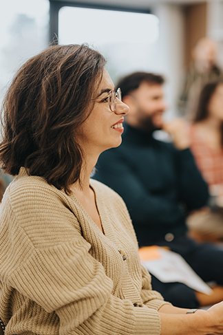 A smiling woman in a mental health group workshop.