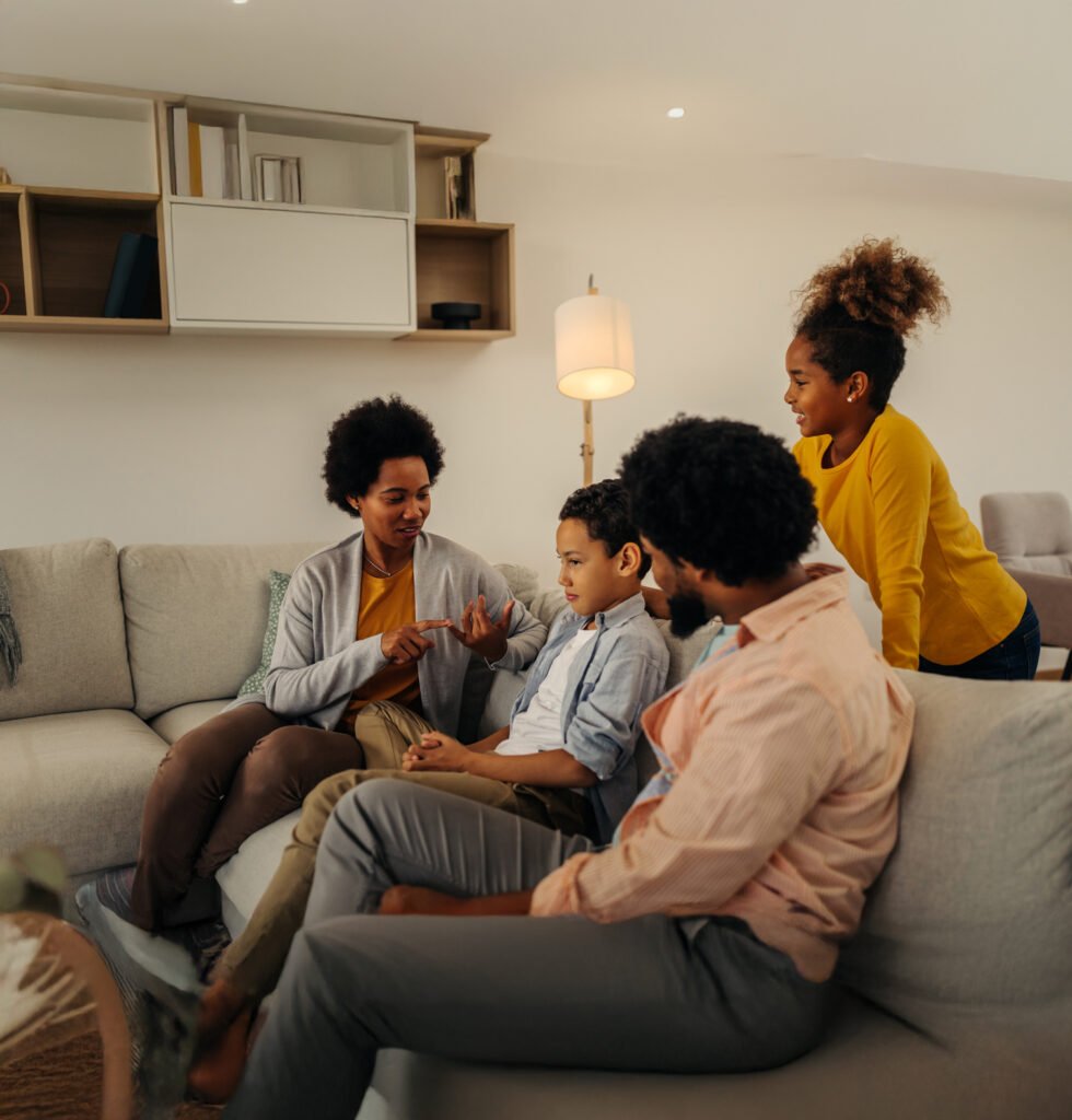 A family talking at home on a couch after family therapy to help with communication skills.